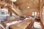Dakota log Cabin dining room with vaulted ceilings and log stairs. 